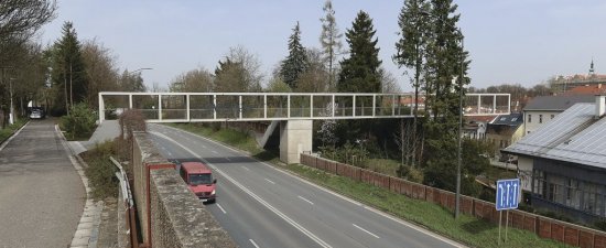 Smetanova lávka z pohľadového betónu a ocele nahradila starší už nevyhovujúci nadchod cez cestu  I/35 z roku 1981.